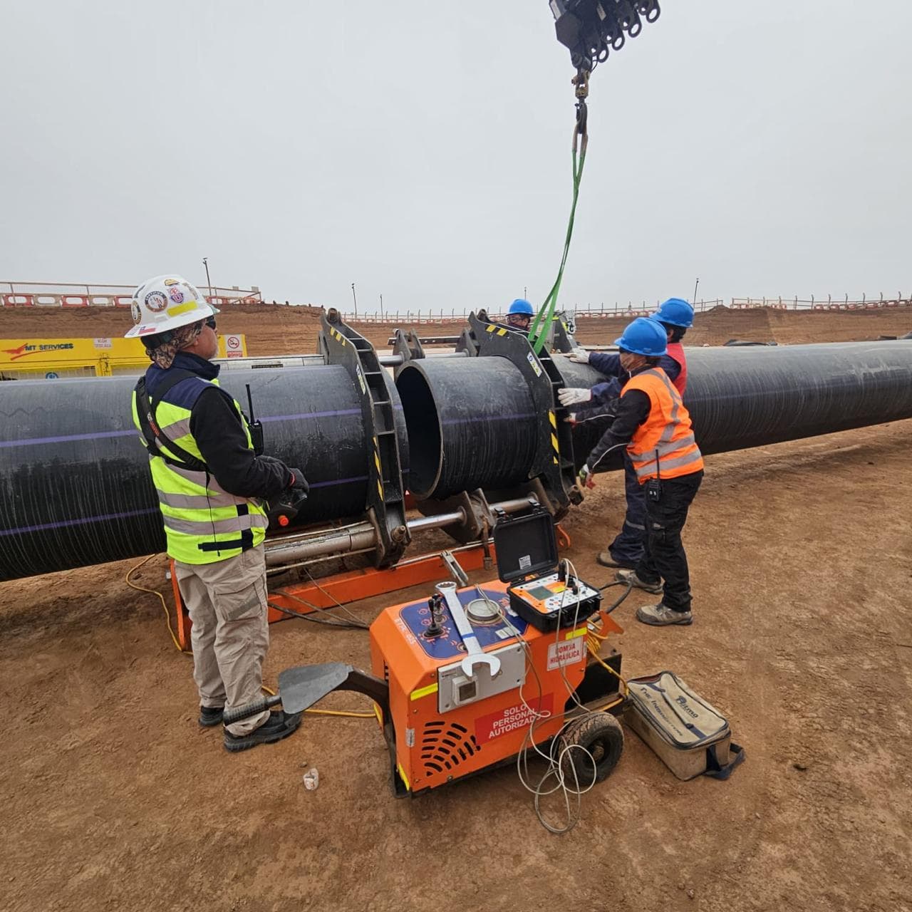 Equipo de AECON operando la máquina de termofusión mientras se iza una tubería HDPE
