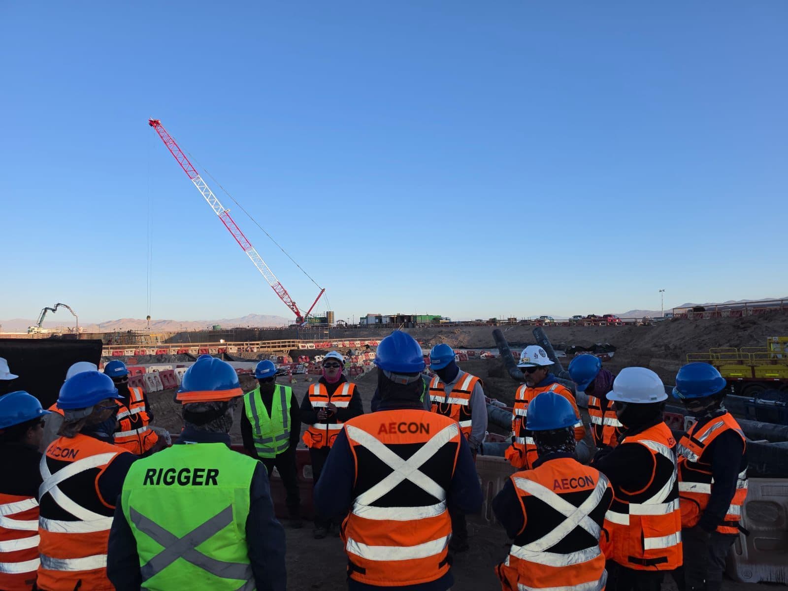 Equipo AECON reunido en terreno antes de una maniobra de izaje, faena en el norte de Chile